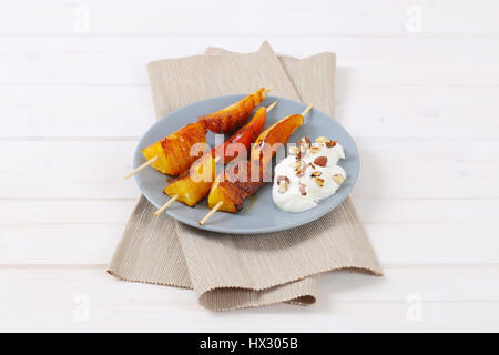 Piastra della pera e arancia spiedini con yogurt, noci tritate e mandorle Foto Stock