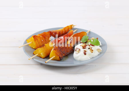 Piastra della pera e arancia spiedini con yogurt, noci tritate e mandorle Foto Stock