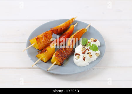 Piastra della pera e arancia spiedini con yogurt, noci tritate e mandorle Foto Stock