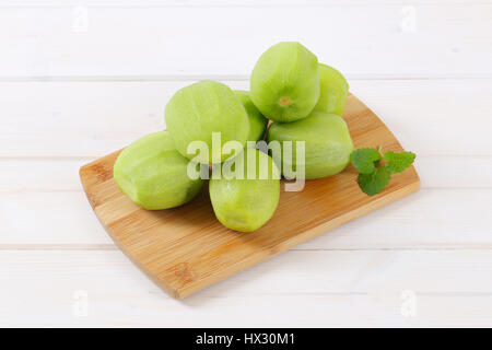 Pila di kiwi sbucciato sul tagliere di legno Foto Stock