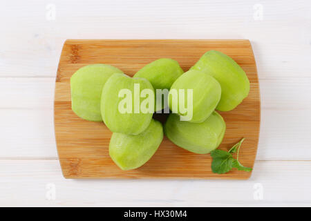 Pila di kiwi sbucciato sul tagliere di legno Foto Stock