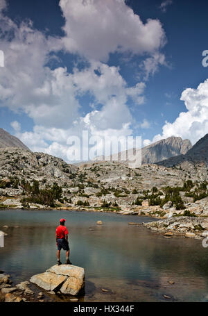 CA03100-00...CALIFORNIA - escursionista presso un tarn su Darwin in Panchina il Kings Canyon Wilderness. Foto Stock