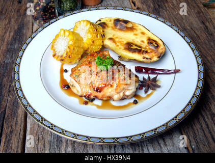 Piccante e speziato di pollo bistecca alla griglia con carbone fuoco pronto a servire foto con illuminazione esterna e mista flash. Foto Stock