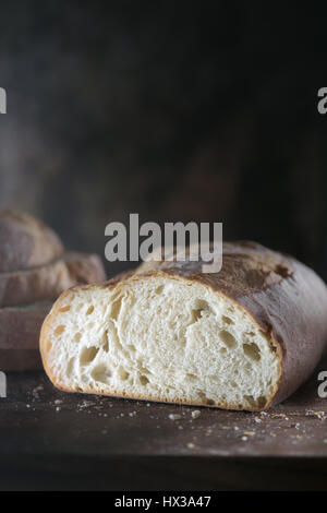 Filone di pane bianco contro uno sfondo scuro Foto Stock