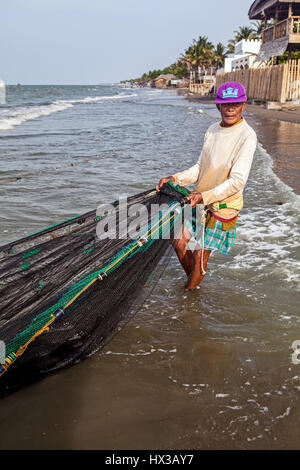 Un vecchio pescatore filippino cattura i pesci con un seine net a Baybay Beach in Roxas City, Panay Island, Filippine. Foto Stock