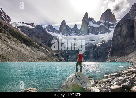 Uomo in piedi sulla pietra sopra il lago vicino Fitz Roy montagna, Patagonia Foto Stock