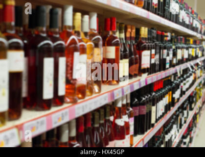 Immagine sfocata di ripiani con bevande alcoliche nel supermercato. Foto Stock