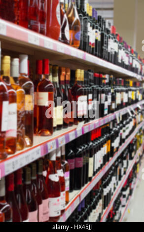 Immagine sfocata di ripiani con bevande alcoliche nel supermercato. Foto Stock