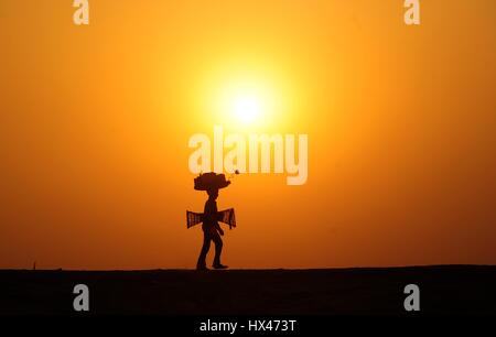 Di Allahabad, Uttar Pradesh, India. 24 Mar, 2017. Un venditore di tornare a casa loro dopo il giorno lungo lavoro durante il tramonto a Sangam a Allahabad, India. Credito: Prabhat Kumar Verma/ZUMA filo/Alamy Live News Foto Stock