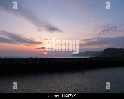 Westbay, Dorset, Regno Unito. Il 24 marzo 2017. Il cloud infine si cancella e un vago ma colorato tramonto segue. Con un meteo alto insieme a seguire e temperature più calde previsto per questo fine settimana. © Dan Tucker/Alamy Live News Foto Stock