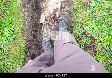 Un primo punto di vista (POV) guardando in giù a gambe e scarponi Foto Stock