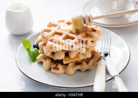 Le cialde con il miele sulla piastra bianca, vista ingrandita. Una gustosa prima colazione Foto Stock