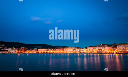 Le luci della città di Trieste che riflette sul mare Foto Stock