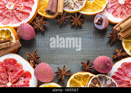 Il Lychee frutti con le fette di agrumi e spezie a stella su sfondo di legno Foto Stock