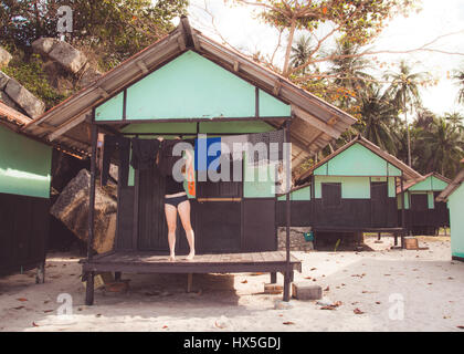 Donna vestiti appesi ad asciugare fuori bungalow sulla spiaggia in Thailandia. Foto Stock