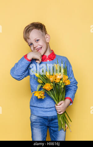 Poco bel bambino con un bouquet di tulipani. Figlio dà la mamma fiori in occasione della Giornata della donna, Giornata della madre. Compleanno. Il giorno di San Valentino. Molla. Foto Stock