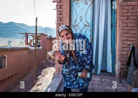 Old Lady davanti a casa sua nel famoso villaggio rosso Abyaneh in Natanz County, Provincia di Isfahan, Iran Foto Stock