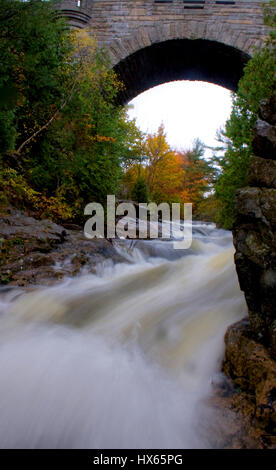 Un fiume precipita sotto un profilo arcuato il ponte di pietra nel Parco Nazionale di Acadia vicino a Bar Harbor, Maine. Foto Stock