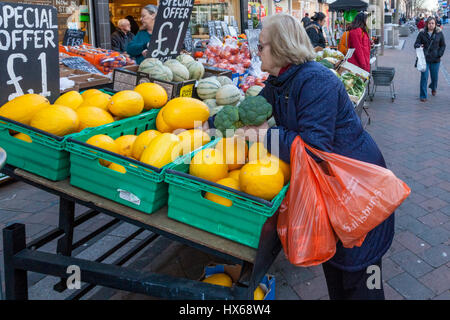 Persona per negozi di frutta e verdura presso un locale negozio di frutta e verdura, Beeston, Nottinghamshire, England, Regno Unito Foto Stock