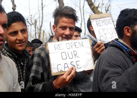 Anantnag, India. 25 Mar, 2017. Un ragazzo tenendo un cartello 'Lettura di riaprire il fake Pathribal incontro caso' in prossimità di un bordo visualizza i nomi delle vittime di Pathribal e massacri Brakpora quando cinque persone uccise nella fase incontro gestito dall esercito e il successivo abbattimento di otto manifestanti nel villaggio Brakpora dalla polizia e CRPF. Credito: Muneeb Ul Islam/Pacific Press/Alamy Live News Foto Stock