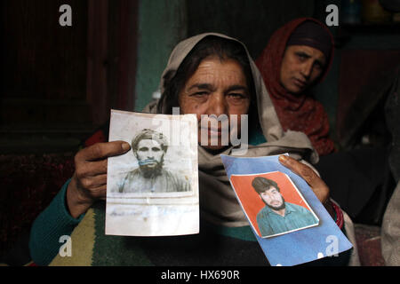 Anantnag, India. 25 Mar, 2017. Zooni moglie e madre di una delle vittime tenendo le foto del suo marito e figlio del xvii anniversario di uccisioni, la vittima le famiglie organizzando un ricordo si incontrano a Brari-Aangan villaggio di Shangus in questo Sud Kashmir distretto per ricordare cinque persone uccise nella fase incontro gestito dall esercito e il successivo abbattimento di otto manifestanti nel villaggio Brakpora dalla polizia e CRPF. Credito: Muneeb Ul Islam/Pacific Press/Alamy Live News Foto Stock