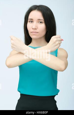 Ragazza mostra le sue mani rompere il suo braccia incrociate isolato su sfondo bianco. Foto Stock