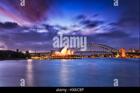 Sydney, Australia - 19 Marzo 2017: World famosi punti di riferimento australiano Sydney Opera House e Harbour Bridge in tutta sfocata acque del porto a colorato Foto Stock