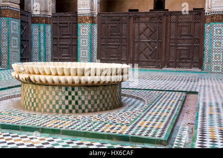 Meknes, Marocco. Medersa Bou Inania, 14th. Secolo. Cortile interno e una fontana. Foto Stock