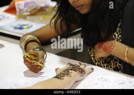 Donna applicando henna arte a portata di mano Foto Stock