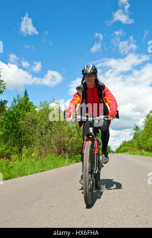 In viaggio per i ciclisti su strada di campagna Foto Stock