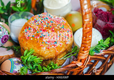 Torta di Pasqua, colorate le uova nel paniere e fiori. Messa a fuoco selettiva. Foto Stock