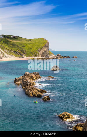 Guardando verso il basso in uomo O'guerra Bay presso un gruppo di mare kayakers negoziando il frastagliato reef nella baia, Jurassic Coast, Dorset, Inghilterra Foto Stock