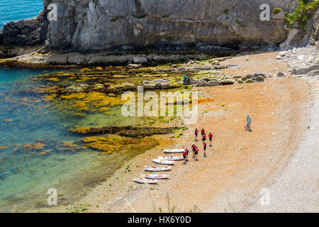 Guardando verso il basso in uomo O'guerra Bay presso un gruppo di kayakers di mare dalla lunga distanza South West Coast Path sulla Jurassic Coast, Dorset, Inghilterra Foto Stock