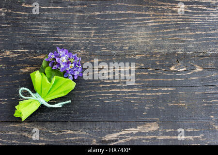 Mazzo di violette nel buio superficie in legno Foto Stock