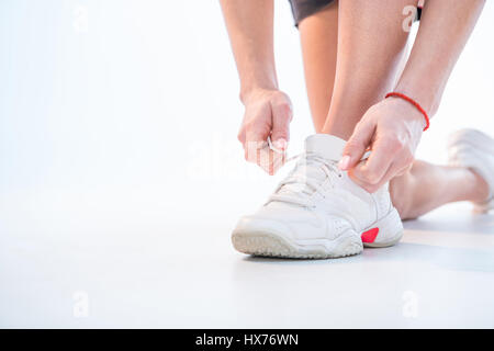 Immagine ritagliata della donna mani lacci delle scarpe di legatura Foto Stock