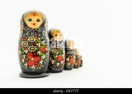 Bella black russian nesting dolls (matrioska bambole) con bianco, verde e rosso dipinto nella parte anteriore del fondo bianco Foto Stock