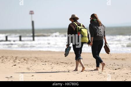 Un giovane tenere le mani come loro a fare una passeggiata sulla spiaggia di Bournemouth nel Dorset. Foto Stock