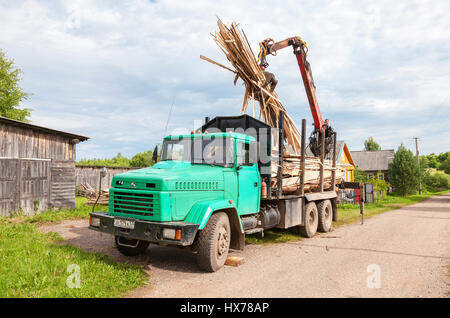 Novgorod, Russia - Luglio 25, 2016: Log manipolatore idraulica legname scaricato dal carrello in giorno di estate Foto Stock