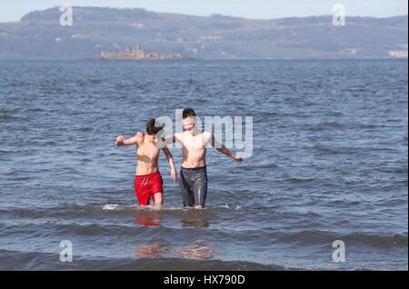 Nota dell'EDITORE: il permesso dei genitori dato amici Daryl Bothwick (sinistra) e Kourosh Soudagar, sia di età compresa tra i 12, fate un tuffo nel Firth of Forth a Silverknowes Promenade di Edimburgo. Foto Stock