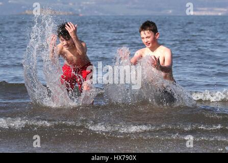 Nota dell'EDITORE: il permesso dei genitori dato amici Daryl Bothwick (sinistra) e Kourosh Soudagar, sia di età compresa tra i 12, fate un tuffo nel Firth of Forth a Silverknowes Promenade di Edimburgo. Foto Stock