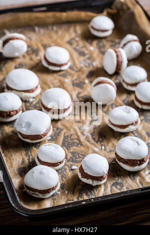 Amaretti al cioccolato su un vassoio da forno sul vecchio tavolo in legno Foto Stock