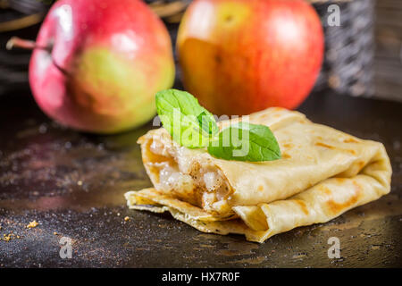 Vista dettagliata del Pancake fatti in casa con le mele sul vecchio tavolo in legno Foto Stock