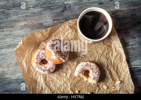 Caffè caldo e ciambelle dato nella carta Foto Stock