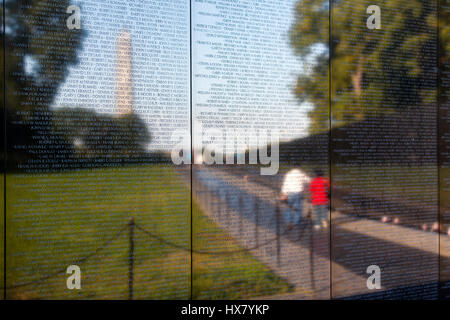 Il Vietnam Veterans War Memorial wall a Washington DC, usa.la parete riflette un paio a piedi e il Monumento a Washington in background Foto Stock