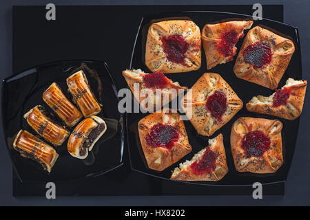 Il papavero e marmellate dolci di forma diversa sul piccolo e grande piazza di piastre in ceramica Foto Stock