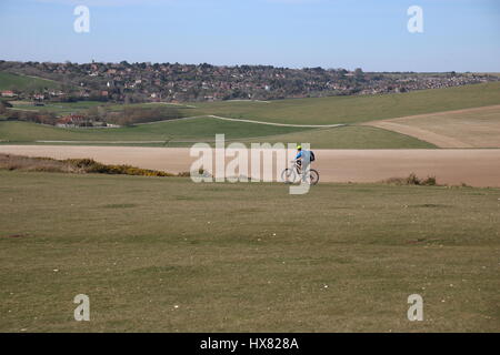 Un ciclista sulla South Downs modo vicino Birling Gap, Eastbourne, Sussex con colline e campi in background Foto Stock