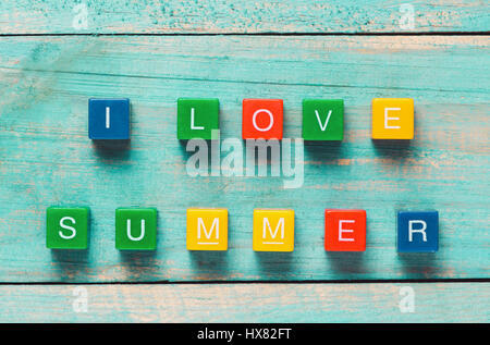 Io amo estate scritto in colorate dei blocchi di legno su una spiaggia Foto Stock