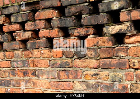 Un muro di mattoni in un vicolo Foto Stock