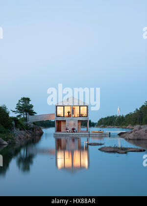 Contestuale complessiva vista esterna al crepuscolo. Casa galleggiante, isola privata, Georgian Bay, il Lago Huron, Canada. Architetto: MOS Architects, 2007. Foto Stock