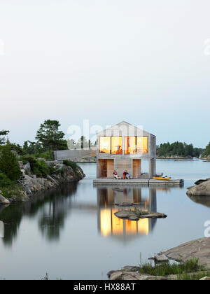 Contestuale complessiva vista esterna al crepuscolo. Casa galleggiante, isola privata, Georgian Bay, il Lago Huron, Canada. Architetto: MOS Architects, 2007. Foto Stock